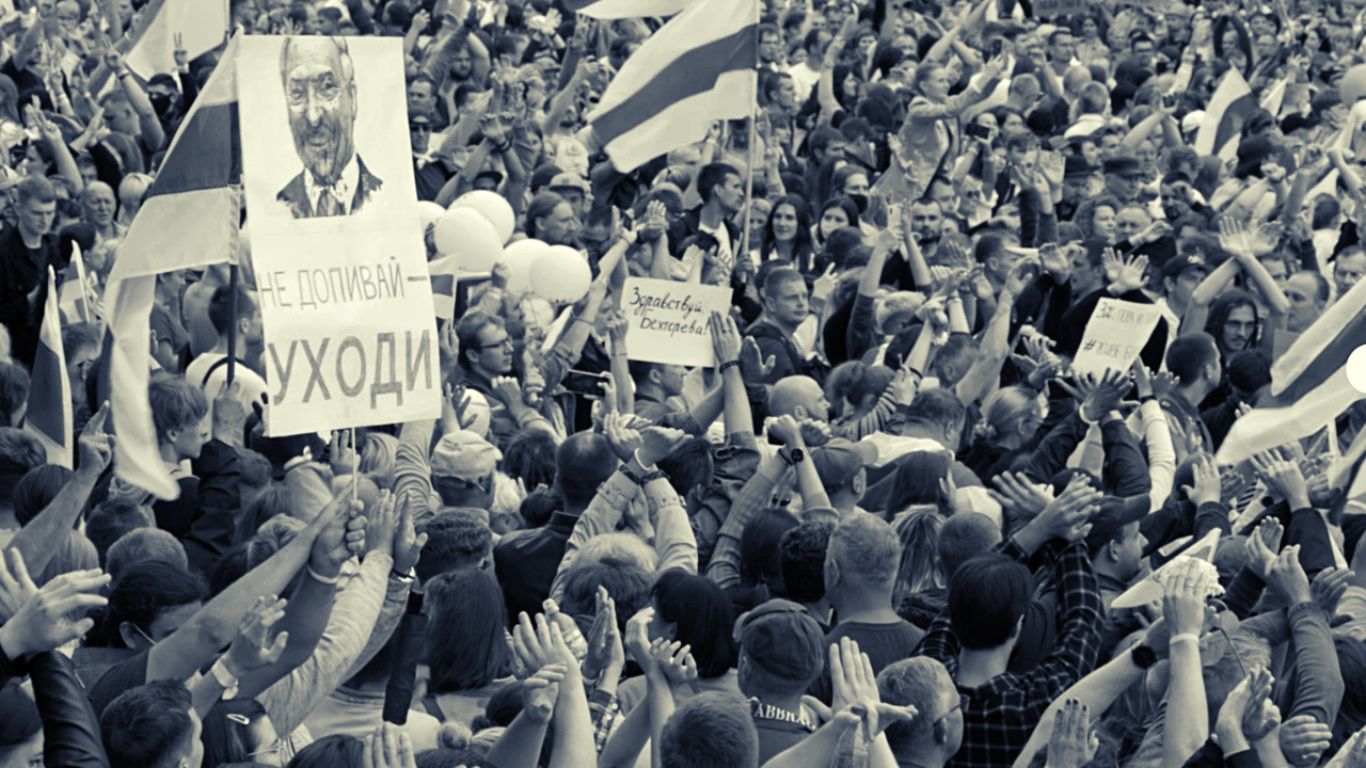 GDY KWIATY NIE MILCZĄ. Zdjęcie przedstawiające tłum ludzi trzymających w dłoniach flagi i transparenty.