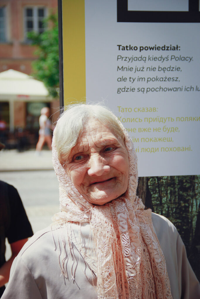 Zdjęcie kobiety na tle wystawy "Wołyń".