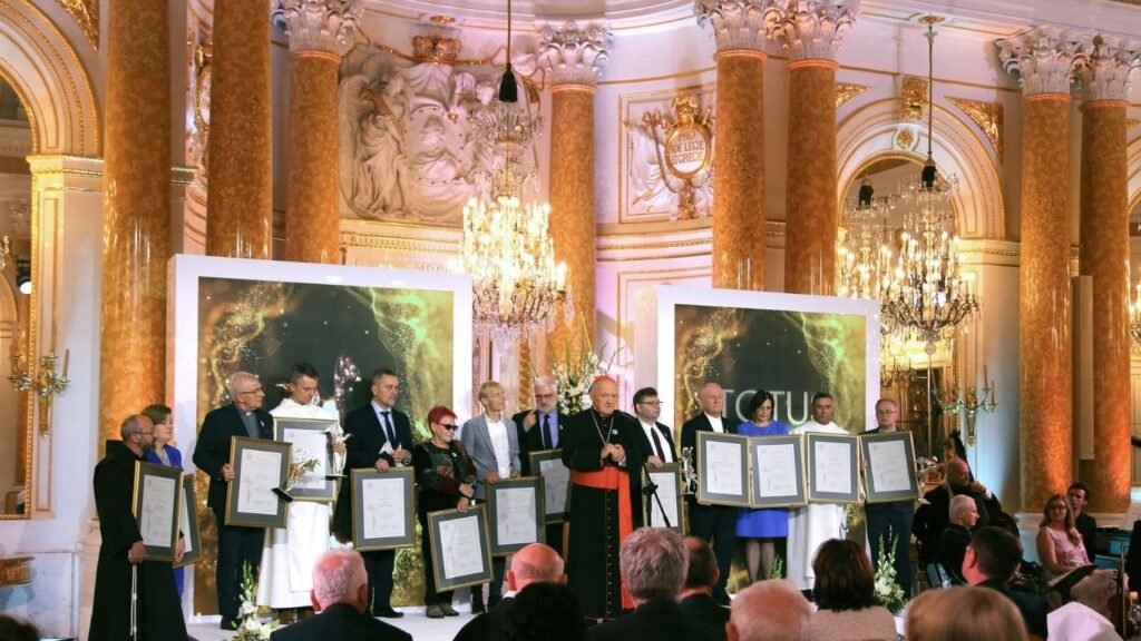 Nagrodzone osoby trzymające dyplomy, pałac