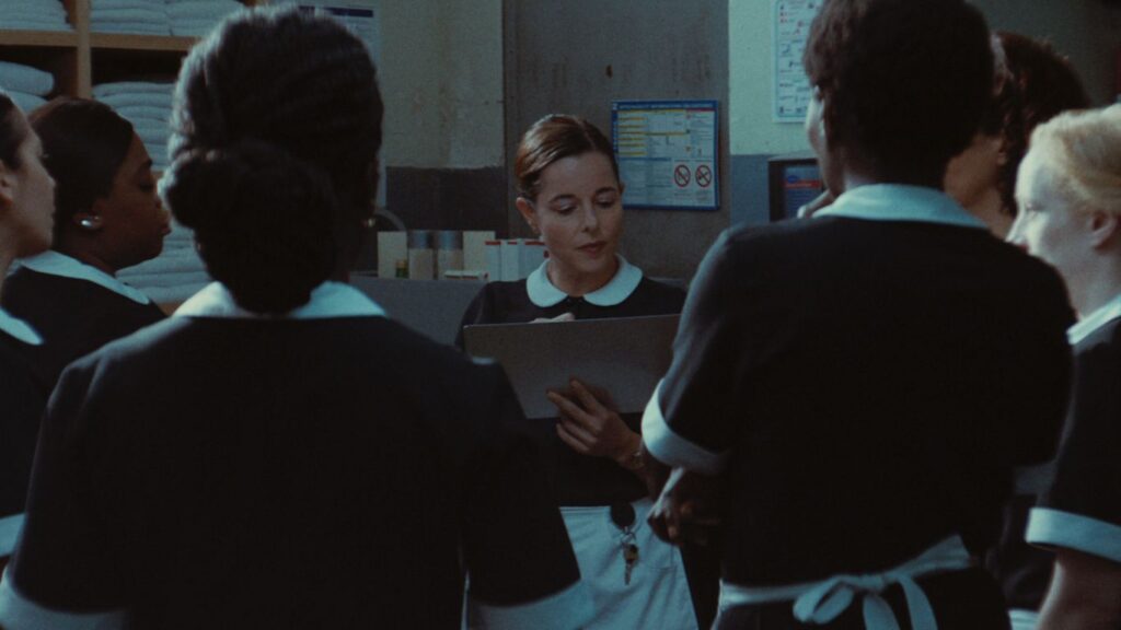 Kadr z filmu, kobieta kelnerka w ubraniu z białym kołnierzykiem